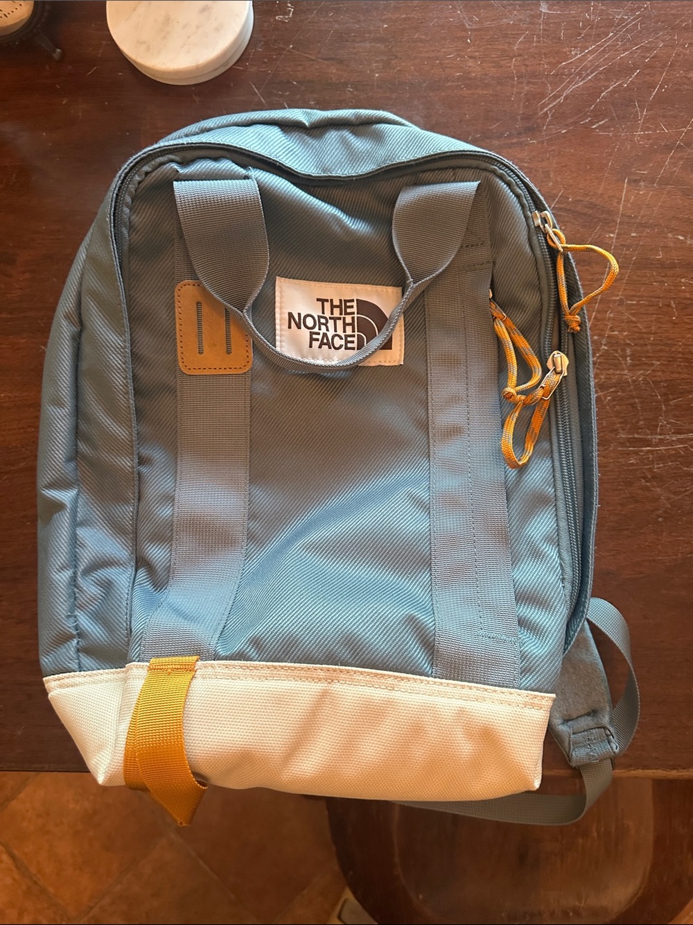 The North Face Light Blue Backpack with White Base and Yellow Accents